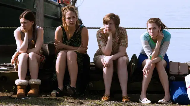Escena de Girls con Jessa, Shoshanna, Hannah y Marnie en un muelle, reflejando un momento de tensión en la serie de Max